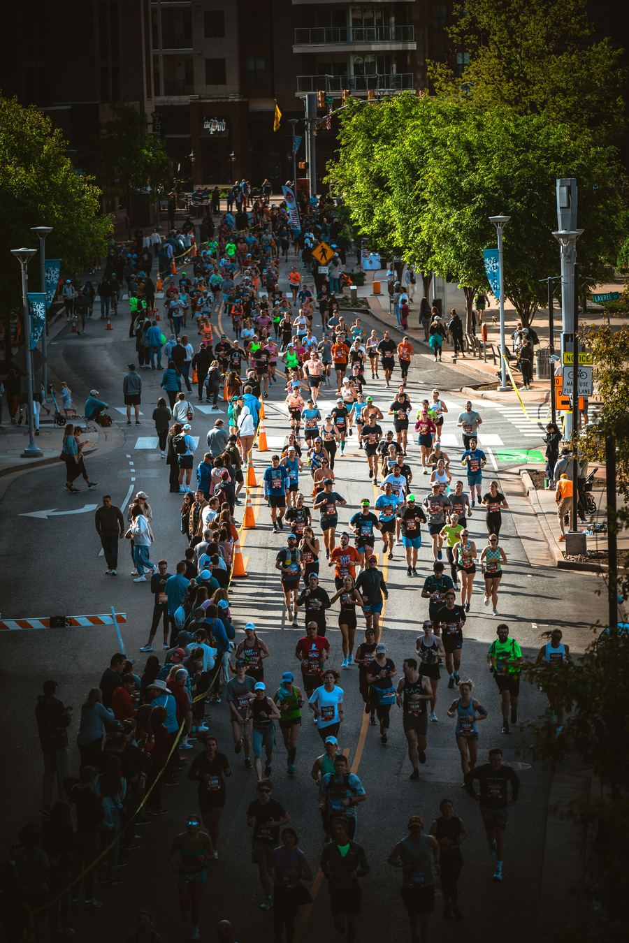 Runners spread across a city avenue during a marathon